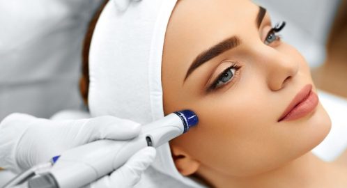 48892779 - face skin care. close-up of woman getting facial hydro microdermabrasion peeling treatment at cosmetic beauty spa clinic. hydra vacuum cleaner. exfoliation, rejuvenation and hydratation. cosmetology.