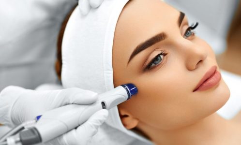 48892779 - face skin care. close-up of woman getting facial hydro microdermabrasion peeling treatment at cosmetic beauty spa clinic. hydra vacuum cleaner. exfoliation, rejuvenation and hydratation. cosmetology.