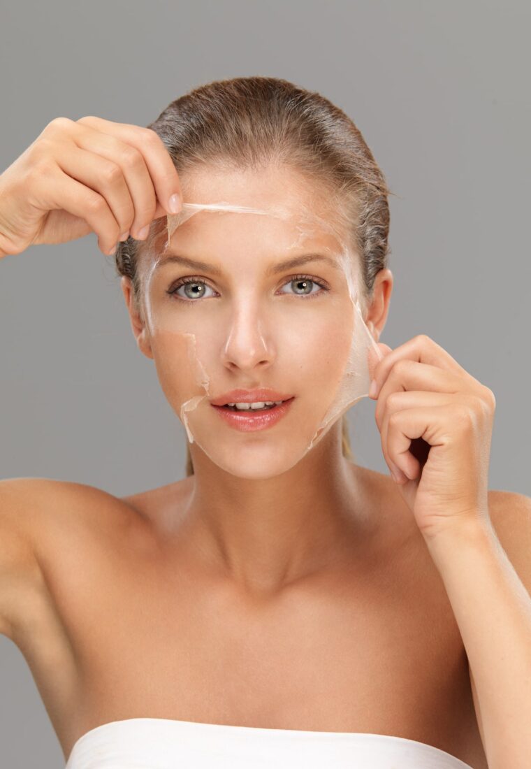 young woman peeling off a facial mask